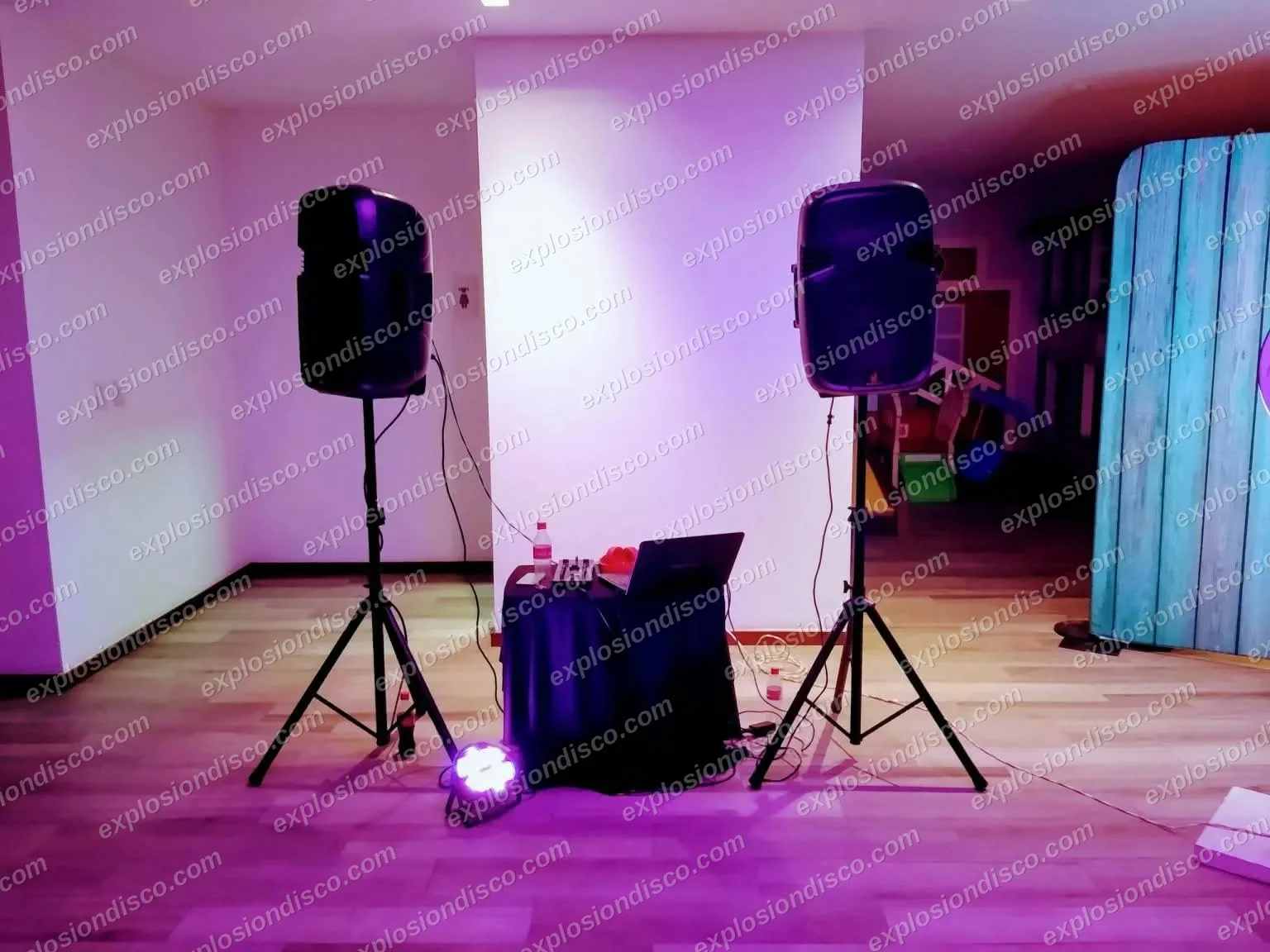 Equipo de sonido con dos bocinas en trípode, mesa de DJ y luz LED en un salón en Guatemala