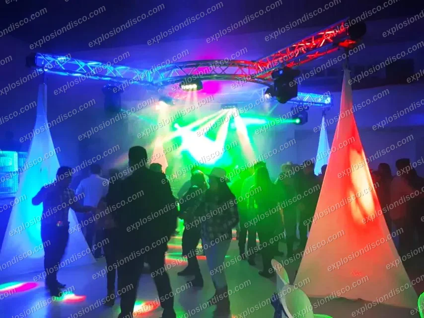 Invitados bailando en una fiesta con estructura de luces, humo y bocinas de discoteca móvil en Guatemala
