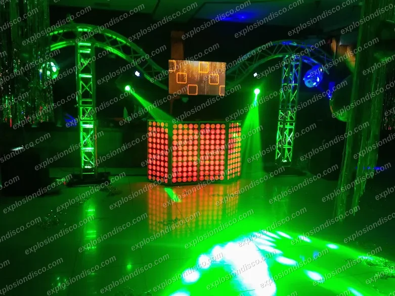 Cabina de DJ con paneles LED, arcos de estructura y luces verdes sobre la pista de baile en un salón en Guatemala